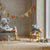 Children's room with Maileg plush toys and a round hanging decoration.