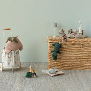 Wicker toy chest with Maileg animals and toys on a neutral background