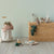 Wicker toy chest with Maileg animals and toys on a neutral background