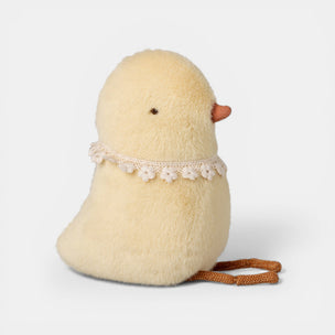 Stuffed toy chick with lace collar on a white background