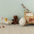 Children's room with toys and furniture against a light green wall.