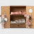 Maileg Two plush toy mice in front of a decorative box with plaid fabric inside.