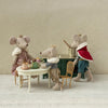 Miniature Maileg mouse figures in a tea party scene with a decorative wall background.