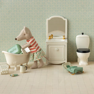 Toy Maileg mouse in a bathroom setting with bathtub, sink, and toilet.