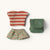 Set of small  Maileg mouse clothing items including a striped shirt, floral skirt, and green pouch on a white background