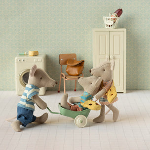 Toy Maileg mice in a miniature room with a washing machine and chair.