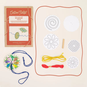 Cotton Twist craft kit with colorful strings and templates on a beige background