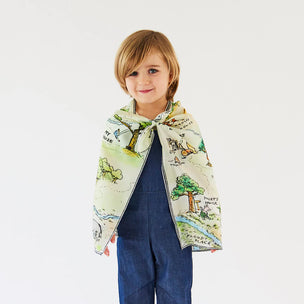 Child wearing a colorful scarf with nature-themed design on a plain background