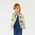 Child wearing a colorful scarf with nature-themed design on a plain background