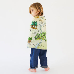 Child wrapped in a map-themed blanket on a white background