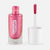 A bottle of metallic pink body gel with the cap off, showing the applicator wand loaded with the same shimmering pink polish, on a light gray background. The brand name 'namaki' is printed vertically on the bottle.
