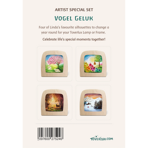 Back of a Toverlux product package featuring an artist special set called Vogel Geluk. The package shows four square wooden frames with colorful nature silhouettes that change yearly, displayed on a light cream background with descriptive text, a barcode, and the Toverlux website.