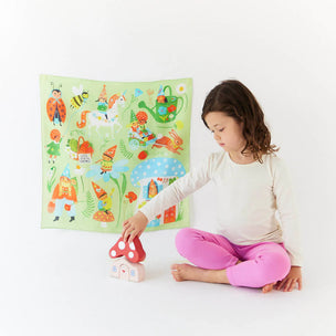 Child playing with toys in front of a colorful poster on a white background