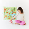 Child playing with toys in front of a colorful poster on a white background