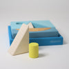 Colorful geometric wooden blocks with a blue storage box on a light gray background