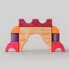 Grimm's Colorful wooden block toy shaped like a castle on a gray background