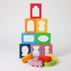 Grmm's Colorful wooden blocks with cut-out shapes stacked on a white background.