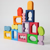 Colorful wooden blocks with various shapes stacked on a light gray background