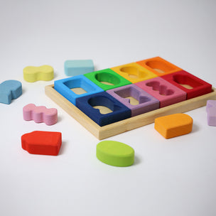 Colorful wooden shape sorter toy with various colored blocks on a white background