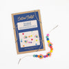 Rainbow beaded bracelet with packaging labeled 'Cotton Twist' on a white background