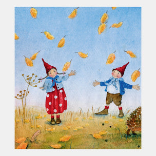 Two children in red hats and outfits standing in a field with falling leaves.