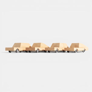Four wooden toy cars arranged in a row on a white background