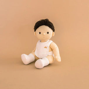 toy baby doll with a rainbow design on a beige background