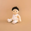 toy baby doll with a rainbow design on a beige background
