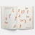 Open book with illustrations of people and animals made from triangles on a white background