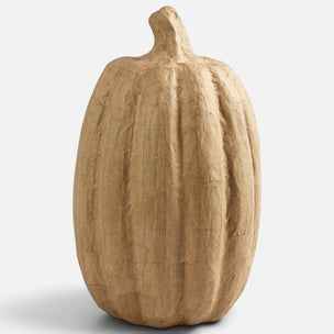 A textured, ribbed decorative pumpkin sculpture in a natural tan clay-like finish, shown on a light gray background.