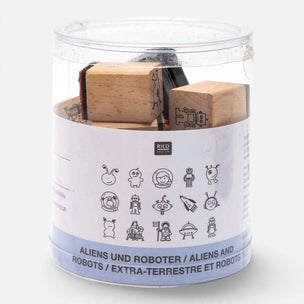 A clear cylindrical plastic container holding wooden rubber stamps with black-engraved alien and robot designs, wrapped in a white and blue label with the brand name RICO design.