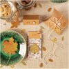 Autumn-themed table setting with leaf cookies, jars, and decorative items on a textured surface.