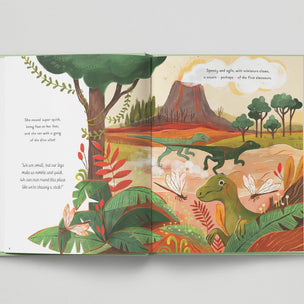 Open book with colorful illustrations of dinosaurs and a volcano on a white background