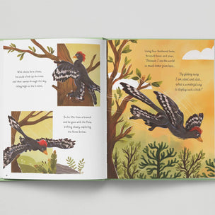 Open book with illustrations of a bird in a forest setting