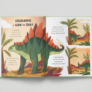 Illustrated book open to a page about Stegosaurus with colorful dinosaurs and plants on a gray background