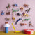 Colorful animal figurines on a pink wall with toys on a yellow surface