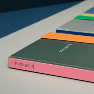 Colorful notebooks with 'PROJECTS' on a gray surface