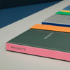 Colorful notebooks with 'PROJECTS' on a gray surface