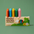 Box of Honey Sticks beeswax crayons with colorful crayons on a green background