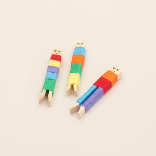 Three colorful wooden toys with striped patterns on a beige background
