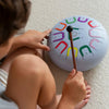Child playing with a colorful toy drum on a carpeted floor