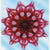 Geometric star-shaped design with red and pink patterns on a blue background