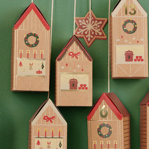 Set of Christmas-themed house-shaped boxes on a green background