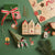 Christmas-themed decorations including houses, trees, and gift on a green background