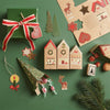 Christmas-themed decorations including houses, trees, and gift on a green background