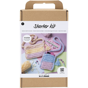 Crochet starter kit packaging with yarn and hooks on a white background