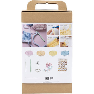 Cardboard box with crochet kit contents on a white background
