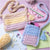 Crocheted bags and phone case with yarn and tools on a colorful background