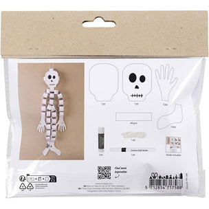Packaged Halloween skeleton craft kit in clear plastic bag with kraft paper header. The package shows printed templates for a head, body, hands, and feet, plus included items like glue stick, glitter, and chalk marker, and a finished skeleton hanging on the left.