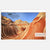 A rectangular printed page or poster showing a desert rock formation with overlaid text reading 'The Wave is made of 190 million-year-old sand dunes that have turned to rock.' The page is centered on a light gray background.